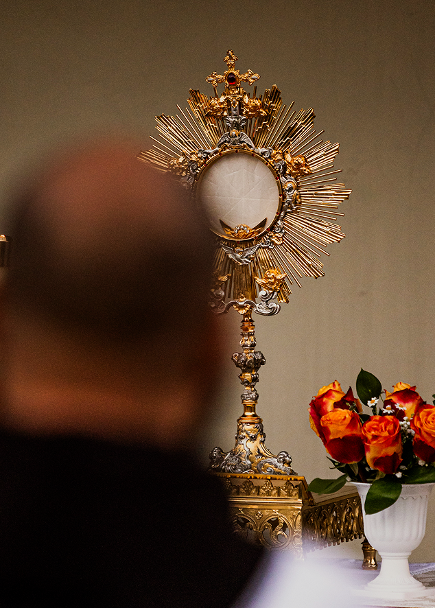 Friar praying before the Blessed Sacrament