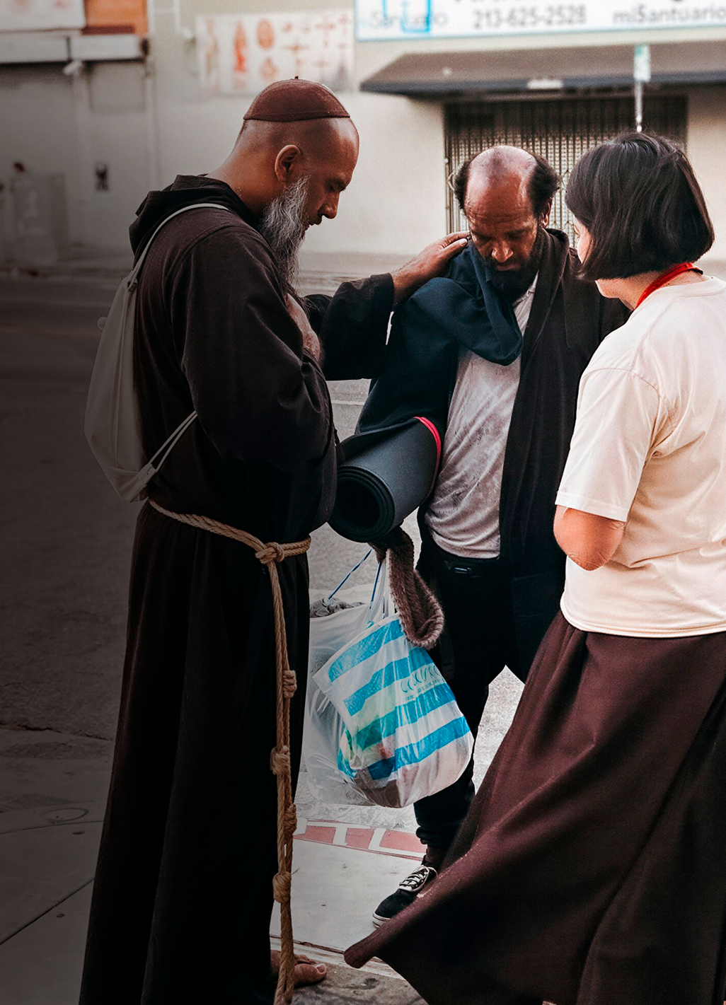 Friar and sister comforting a man on the street