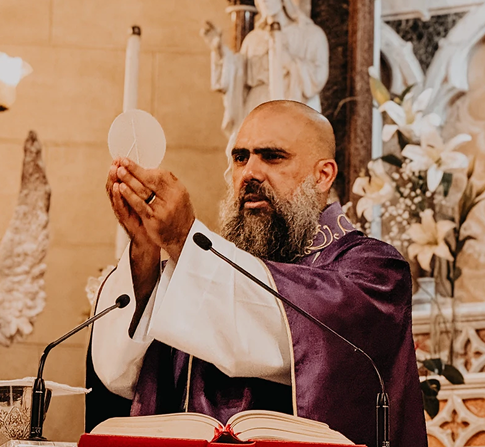 Friar elevating the Eucharist