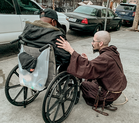 Friar with a person in a wheelchair
