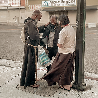 Friars talking to a man